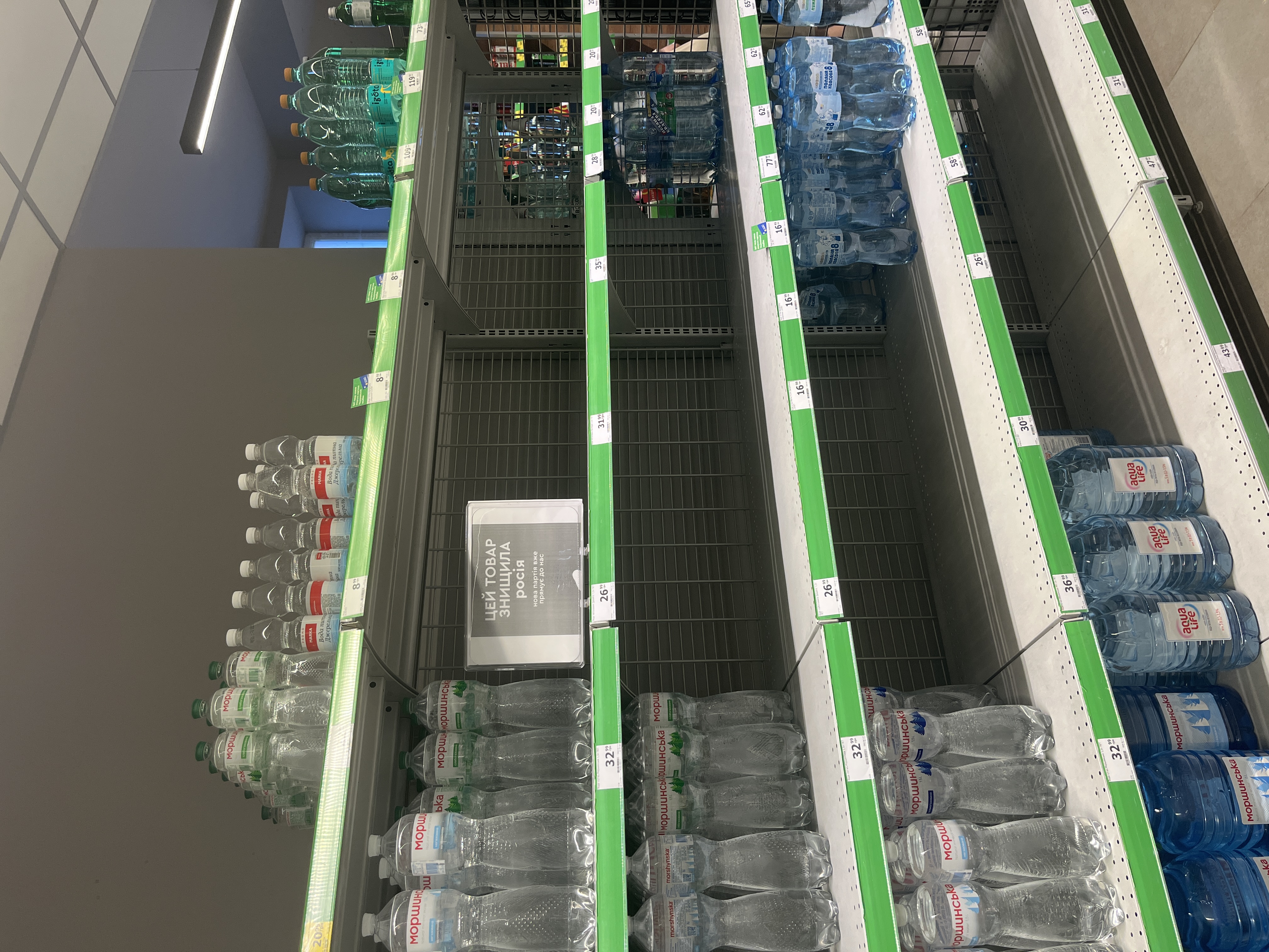 Empty shelves in a Kyiv supermarket following Russian strikes on warehouses and shopping centres. A sign reads: "This product was destroyed by Russia". Photo credit: Kateryna Zudenkova
